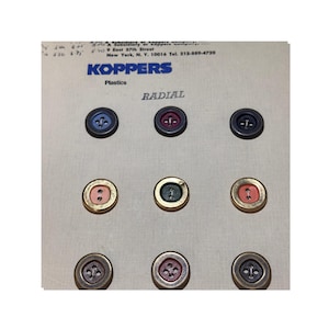 May include: A selection of buttons in diverse colours and styles, including blue, red, green, and gold. The buttons are displayed on a light beige surface with the text "KOPPERS Plastics" and "RADIAL".