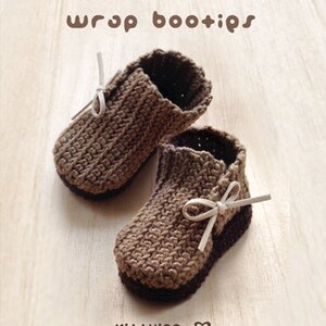 May include: A pair of brown crocheted baby booties with white ribbon ties. The booties have a textured knit pattern and are called "wrap bootips".