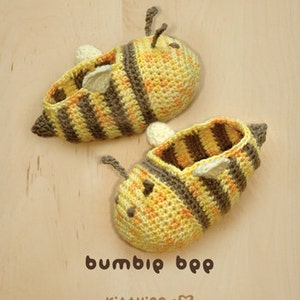 May include: A pair of crocheted bee-shaped baby booties in yellow and brown with black stripes. The booties have a small crocheted bee antenna on top.