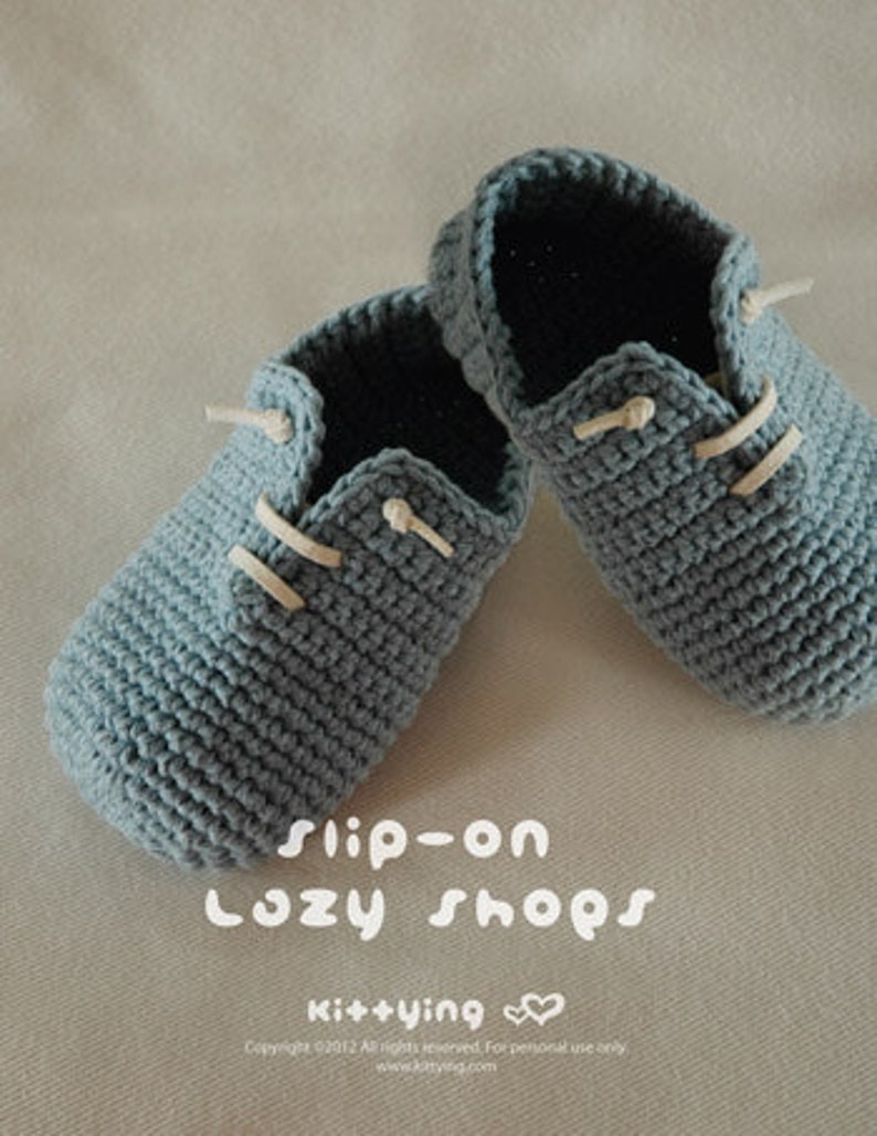 May include: A pair of blue crocheted slip-on shoes with white laces. The shoes are made with a textured stitch and have a simple design. The text "Slip-on Cozy Shops" and "Kit+ying" is visible on the image.