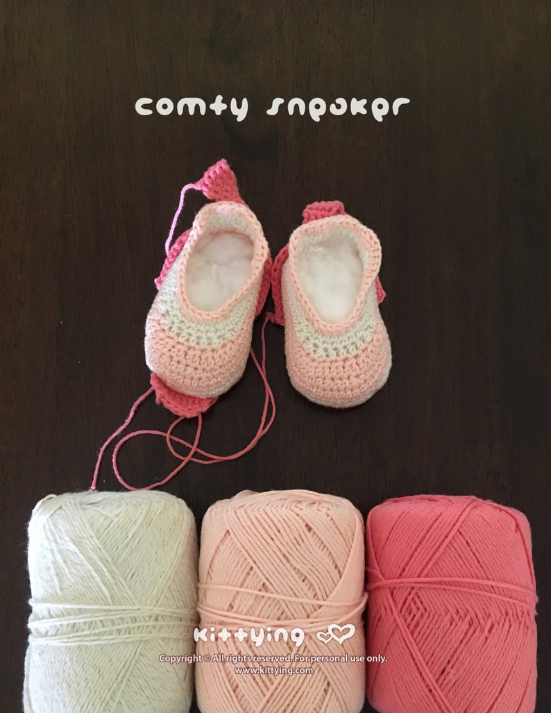 May include: A pair of pink and white crocheted baby booties with a pink yarn ball, a light pink yarn ball, and a darker pink yarn ball. The booties are labeled "comty sn&rho;&omicron;&kappa;&rho;&omicron;" and "Kit+ying".