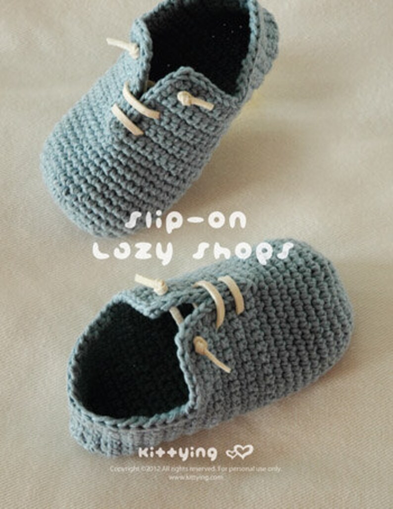 May include: A pair of gray crocheted slip-on shoes with white laces. The shoes are made with a simple stitch pattern and have a rounded toe.