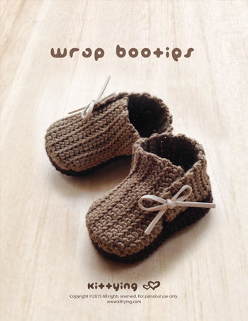 May include: A pair of brown crocheted baby booties with white ribbon ties. The booties are on a light brown wooden surface. The text "wrap bootips" is at the top of the image. The text "Kit+ying" is at the bottom of the image.