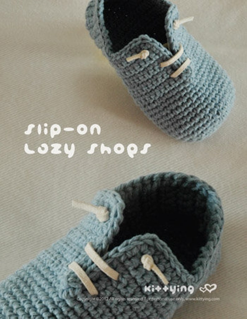 May include: A pair of crocheted baby shoes in a light blue color with white laces. The shoes are slip-on style and have a simple design. The text "slip-on Lazy Shops" is visible in the image.