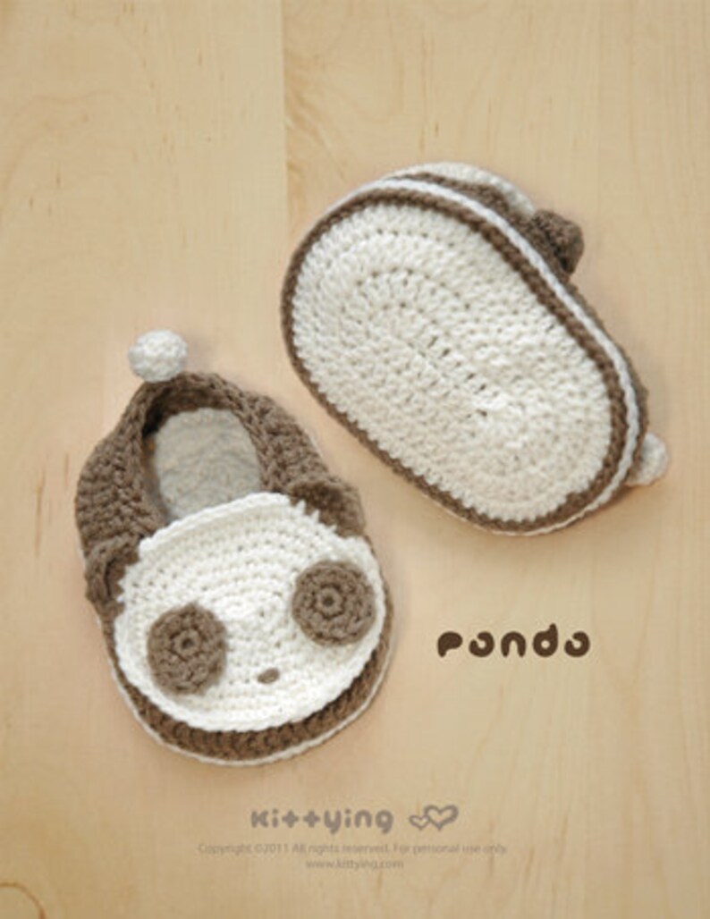 May include: A pair of brown and white crocheted baby booties with a panda face design. The booties have a white sole and a brown trim. The text "Pondo" is visible below the booties.