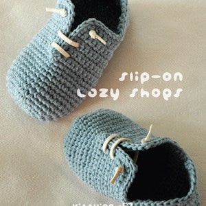 May include: A pair of blue crocheted slip-on shoes with white laces. The shoes are called "Cozy Shops".