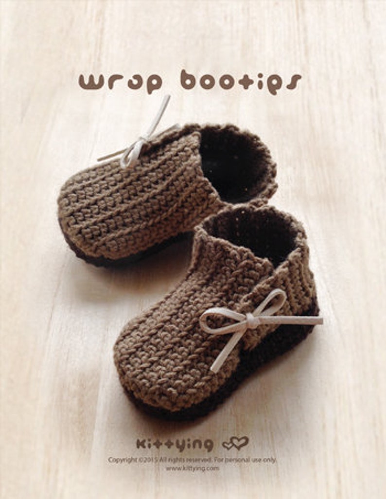 May include: A pair of brown crocheted baby booties with white ribbon ties. The booties are made with a textured stitch and have a simple, classic design.