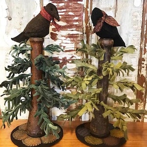 Może przedstawiać: Dwa czarne ptaki z filcu z czerwonymi i białymi kratkowanymi szalikami, które siedzą na zielonych drzewach z filcu z brązowymi podstawami. Drzewa stoją na brązowej powierzchni.