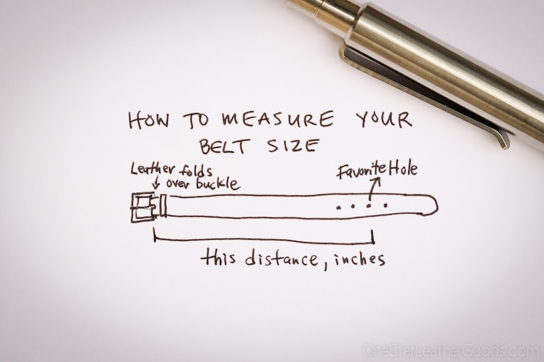May include: Handwritten instructions on how to measure your belt size in inches. The illustration shows a belt with a buckle and multiple holes. The text indicates to measure the distance from the buckle to the hole you use most often.