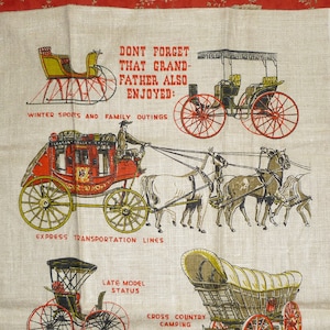 Op de afbeelding: Een vintage linnen theedoek met een kleurrijke illustratie van paardenkoetsen en wagens. De tekst luidt "Vergeet niet dat grootvader ook genoot van: Wintersport en familie-uitjes, Express-transportlijnen, Recente modelstatus, Cross-country camping, Nieuws - onlangs aangekomen uit de stad."