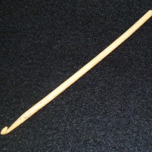 Pu&ograve; includere: Un primo piano di un uncinetto di legno di colore marrone chiaro.