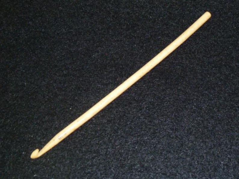 Pu&ograve; includere: Un primo piano di un uncinetto di legno di colore marrone chiaro.