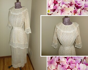 May include: A white vintage dress with a lace collar and trim. The dress has a fitted bodice and a full skirt. The dress is on a mannequin.