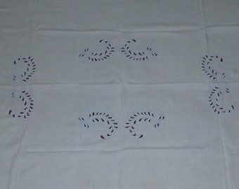 Könnte beinhalten: Weiße Tischdecke mit einem zarten Stickmuster. Die Stickerei zeigt ein sich wiederholendes Muster aus stilisierten Blättern in hellblauer Umrandung mit burgunderfarbener Füllung.