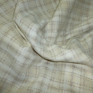 May include: A close-up of a beige and white checkered fabric with a textured weave. The fabric is soft and has a subtle sheen.