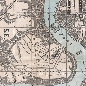 May include: A vintage map of the Thames River in London, England, showing the docks and surrounding areas. The map is printed in black and white on a light blue background. The map includes the names of various docks, including the "Inner Dock", "Outer Dock", "Commercial Dock", and "Surrey Dock". The map also includes the names of various streets and roads, including "Shadwell", "Wapping", and "Limehouse Reach".