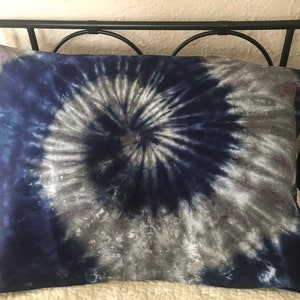 May include: A blue and white tie-dye pillowcase with a spiral pattern.