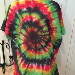 May include: A tie-dye t-shirt with a spiral pattern in shades of red, green, yellow, and black.