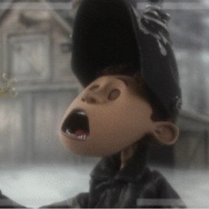 May include: A close-up of a character with a black hat and a wide open mouth, looking up in surprise. The character is holding a long, thin object in their hand.