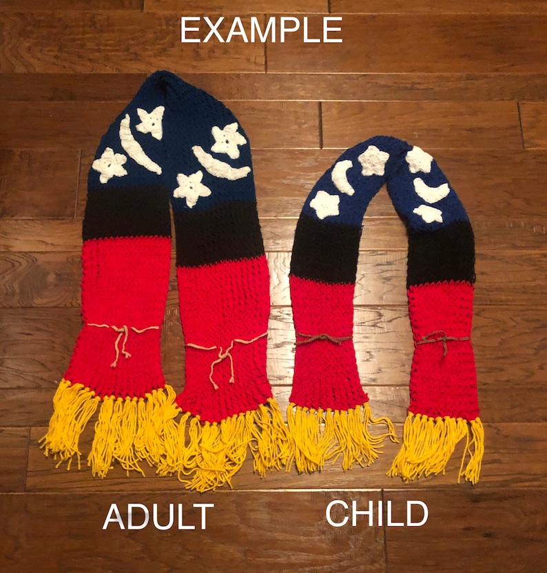 May include: Two crocheted scarves with a blue, black, and red striped pattern and white crescent moon and star designs. The larger scarf is labeled "Adult" and the smaller scarf is labeled "Child".