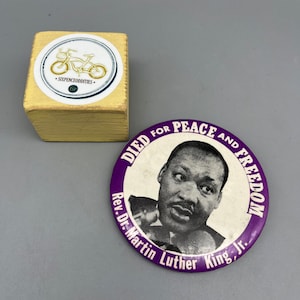 May include: Purple button with a white image of Martin Luther King Jr. with the text "Died for Peace and Freedom Rev. Dr. Martin Luther King, Jr."