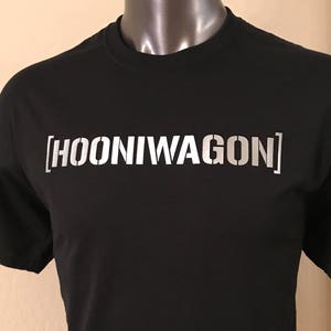 Puede incluir: Camiseta negra con un gr&aacute;fico blanco que dice "[HOONIWAGON]"