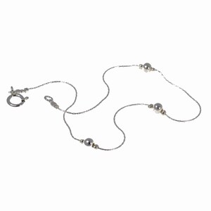 May include: A silver chain necklace with three silver beads.