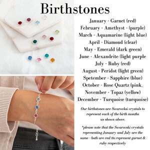 May include: A silver bracelet with a row of colorful Swarovski crystals representing birthstones for each month of the year. The crystals are red, purple, light blue, clear, dark green, light purple, red, light green, blue, pink, yellow, and turquoise. The text below the bracelet reads: "Our birthstones are Swarovski crystals to represent each of the birth months as shown above. *please note that the Swarovski crystals representing January and July are the same - both are red to represent garnet & ruby respectively"