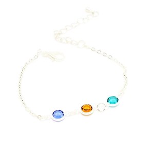 May include: A silver chain bracelet with four round gemstones. The gemstones are blue, orange, and green.