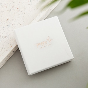 May include: White square box with the text "poppy & co. jewellery" in gold lettering.