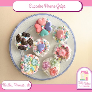 May include: Assortment of seven cupcake phone grips with various toppings, including sprinkles, hearts, and chocolate pieces. The grips are designed to look like cupcakes and are perfect for adding a touch of whimsy to your phone.