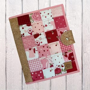 May include: A white ceramic mug with a black handle and the text "But First, Coffee" in a bold, black font. The mug is set against a blurred background, suggesting a cozy setting.