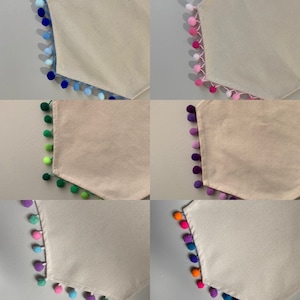 May include: Six table runners with different colored pom-pom trim. The table runners are all a natural beige color and have a hexagonal shape.