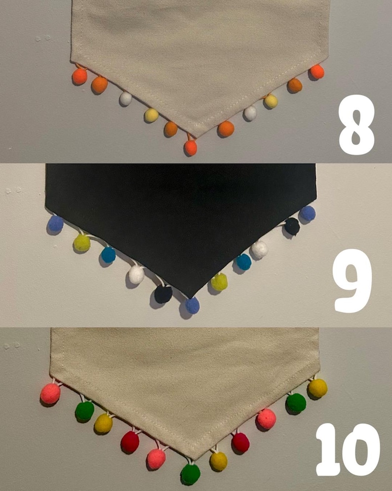 May include: Three fabric bandanas with different colored pom-poms around the edges. The first bandana is white with orange pom-poms, the second is black with blue pom-poms, and the third is beige with green, yellow, red, and pink pom-poms.