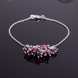 以下が含まれることがあります： ピンクとグリーンの宝石ビーズのクラスターが付いたシルバーチェーンブレスレット