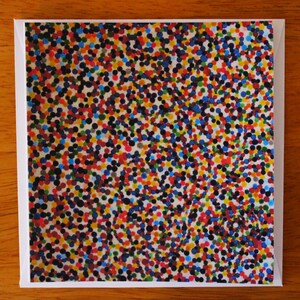 May include: A white card with a colourful pattern of small dots in shades of red, blue, green, yellow, and black.