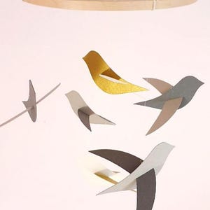 Giostrina 6 uccellini grigi e dorati su cerchio di legno in carta riciclata 20x45cm.