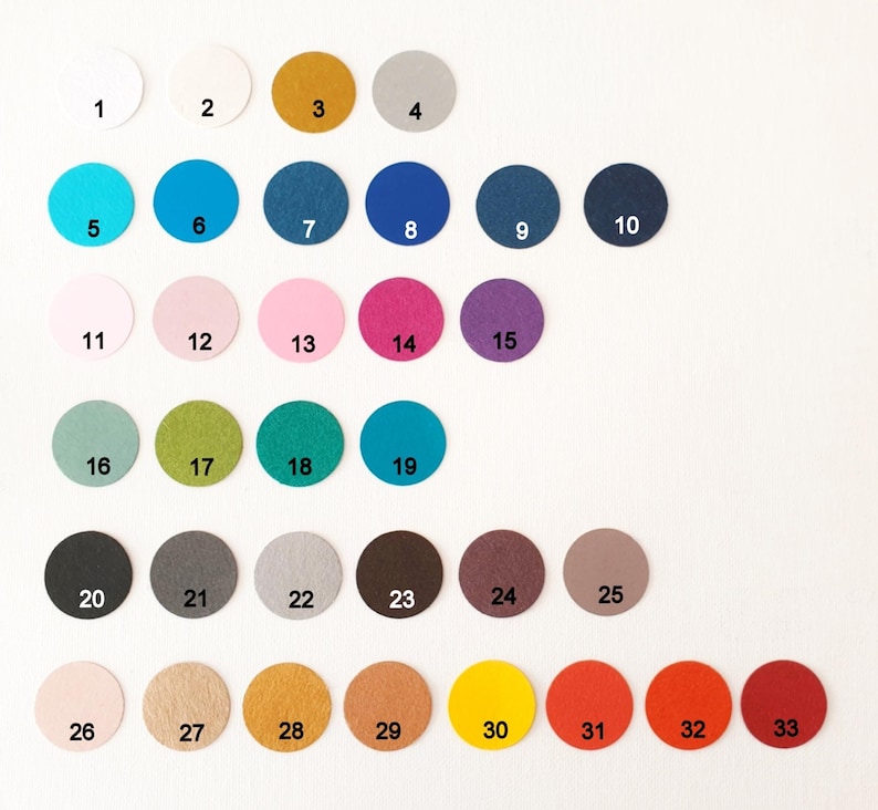 May include: A collection of thirty-three circular felt swatches arranged in rows, each labelled with a black number from 1 to 33. The swatches display a wide spectrum of colours including white, yellow, grey, blue, pink, purple, green, brown, and red.