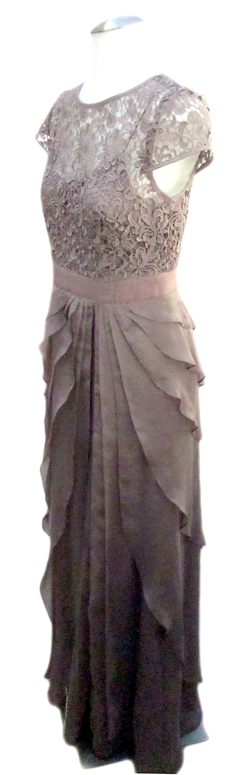 May include: A mauve lace and chiffon dress with a ruffled skirt. The dress has a fitted bodice and short sleeves.