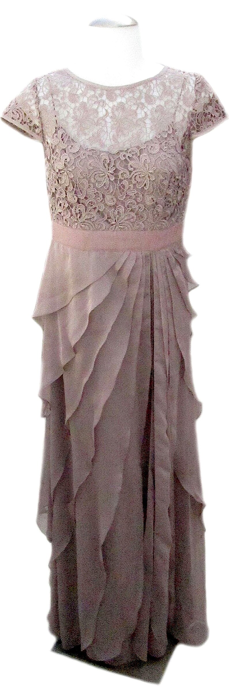 May include: A mauve lace and chiffon dress with a ruffled skirt. The dress has short sleeves and a scoop neckline.
