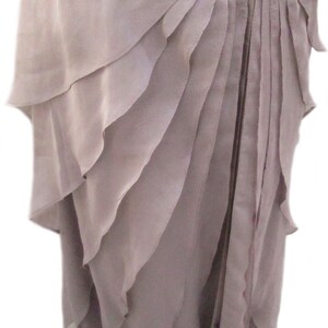May include: A mauve-colored dress with a layered ruffle skirt. The skirt is made of a soft, flowing fabric and has a delicate, feminine look.