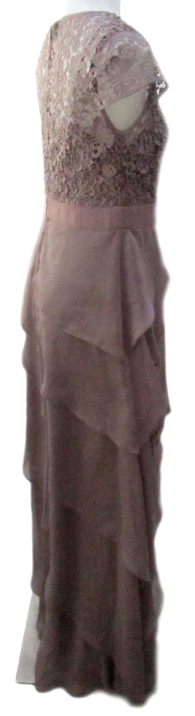 May include: A mauve lace and chiffon maxi dress with a ruffled skirt. The dress has a fitted bodice and a wide lace band at the waist.