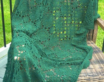 May include: A dark forest green crochet blanket featuring a repeating circular motif pattern. The textile is crafted with fine yarn, creating an intricate, openwork lace design that drapes over the surface with a soft, textured appearance.