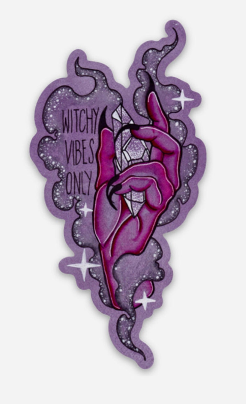 May include: A purple and pink hand with long, sharp nails holds a large, clear crystal. The hand is surrounded by a purple and white smoky cloud with white stars. The text "Witchy Vibes Only" is written in black on the cloud.