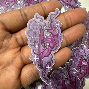 May include: Purple and white sticker with a hand holding a crystal and the text "Witchy Vibes Only".