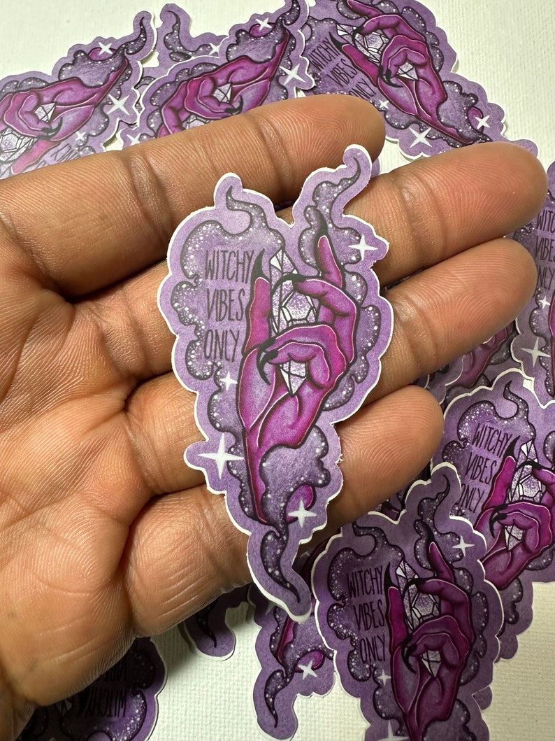 May include: Purple and white sticker with a hand holding a crystal and the text "Witchy Vibes Only".