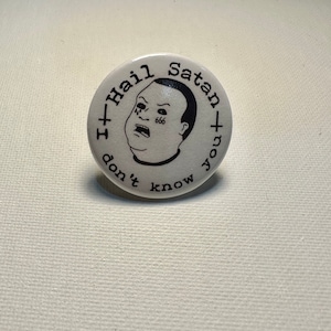 Puede incluir: Un botón blanco con texto negro y una imagen de dibujos animados. El texto dice "I+Hail Satan+You don't know". La imagen de dibujos animados es de una persona con una lágrima corriendo por su mejilla y el número 666 en su frente.