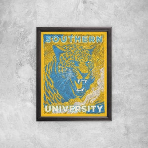 May include: A framed poster with a blue and yellow illustration of a snarling jaguar. The poster reads "SOUTHERN UNIVERSITY" in bold, white letters.