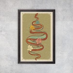 May include: A framed print of a stylized illustration of a red and green snake with a blue and green pattern winding around itself. The snake is surrounded by four flowers in shades of pink, yellow, and white. The background is a light green with a subtle pattern.