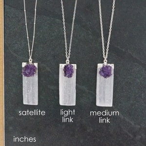 May include: Three selenite crystal pendants with amethyst points, each on a silver chain. The pendants are labeled "satellite", "light link", and "medium link".
